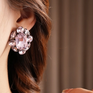 Gros plan sur les boucles d'oreilles flocon vintage avec cristaux roses en grappe