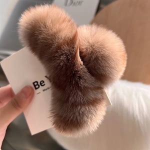 Macro view of soft warm brown fluffy rabbit fur hair claw clip with dense texture