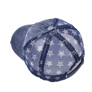 Detail of blue denim trucker hat featuring mesh back with white star pattern and top button