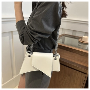 Détail du sac bandoulière blanc asymétrique en cuir avec bandoulière chaîne argent