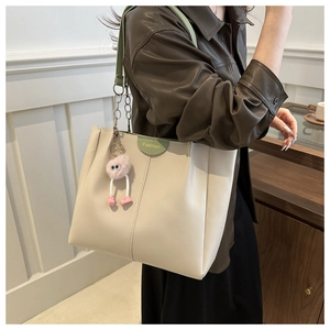 Dettaglio della borsa tote in pelle PU bianco crema con tracolla verde e catena
