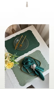 Macro detail of heat-resistant green leather placemats with elegant scalloped edges