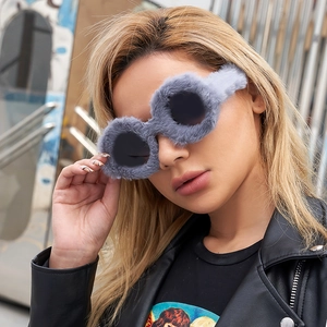 Detail shot of round sunglasses with gray plush fur trim for a trendy street style look
