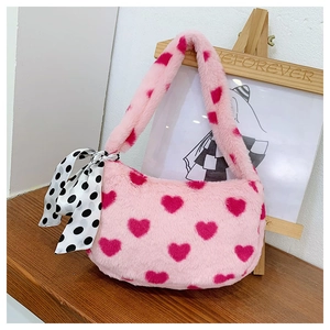 Detail of pink plush handbag with heart patterns and black and white polka dot scarf