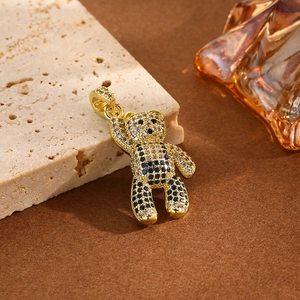 Hiphop iced out gold teddy bear pendant with blue stones on a decorative stone base