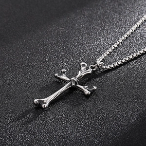 Macro detail of gothic silver cross pendant featuring a realistic bone texture design