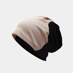 Detail view of the two-tone knit beanie with beige and black ribbed texture for winter