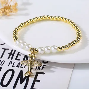 Detail of beaded bracelet with gold airplane charm and micro-inlaid zircon pearls