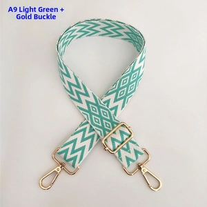 Detail of adjustable woven bag strap in light green geometric pattern with gold buckles