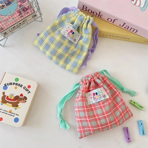 Gros plan sur des sacs de rangement à cordon à carreaux colorés avec étiquette