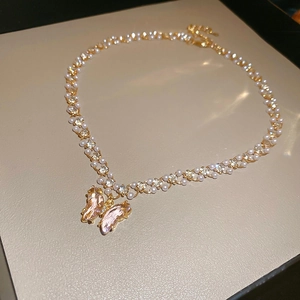 Detailed view of butterfly pendant with pink zircons and double-row pearl chain