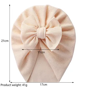 Solid color baby turban hat with oversized bow decoration and detailed size measurements