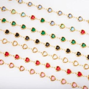 Detail of gold heart charms on chains featuring colorful glass stones in multiple shades