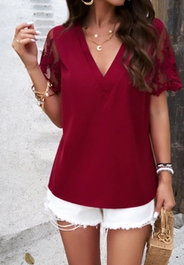 Close-up of wine red V-neck blouse featuring intricate lace embroidery on short sleeves