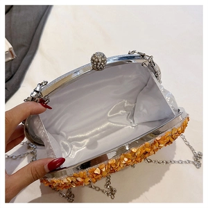 Detailed view of pumpkin evening bag with yellow shells, silver chain, and satin interior