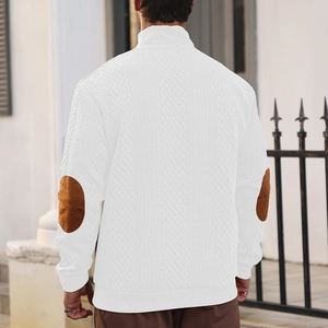 Detail of white knit sweater showing brown elbow patches and textured jacquard pattern