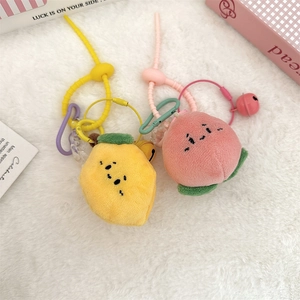 Détail de porte-clés en peluche citron et pêche avec cordons colorés et grelots