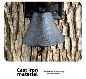 Detailed close-up of dark grey cast iron bell texture mounted on a garden tree trunk