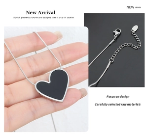 Detail of silver heart pendant necklace with black enamel inlay and snake chain design