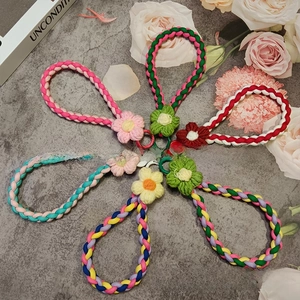 Detail view of colorful handmade braided phone lanyards with crochet flower charms