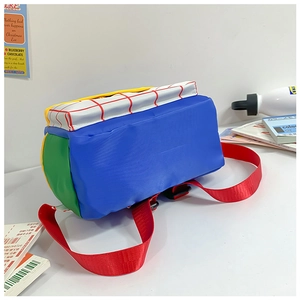 Detail of color-block canvas kids backpack with blue, red grid, and green side pocket