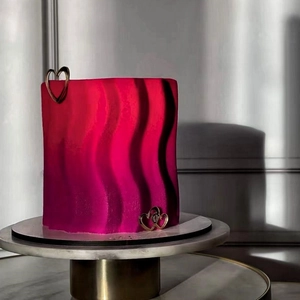 Détail d'un gâteau ondulé avec dégradé magenta et décorations de cœur dorées