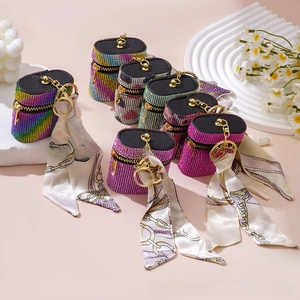 Close-up of rhinestone lipstick cases with printed silk scarves and keychain hooks