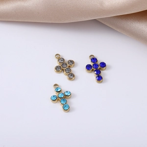 Detailed view of colorful rhinestone cross charms in gold titanium steel for DIY jewelry
