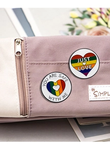 Detail of Just Love and You Are Safe With Me rainbow heart pins on a pink pencil case