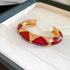 Detailed shot of vintage French style gold brushed metal cuff with red enamel triangles