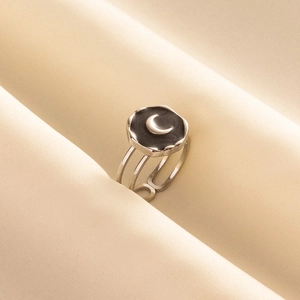 Macro detail of crescent moon relief on a silver vintage-style triple-layered open ring