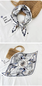 Detail of pleated silk scarf with vintage nautical print and textured zigzag edges