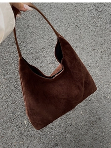 Detail of a large brown faux suede Hobo shoulder bag shown in a handheld perspective