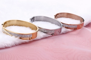 Detail of three-piece stackable bangle set with pavé rhinestones in gold, silver, and rose gold