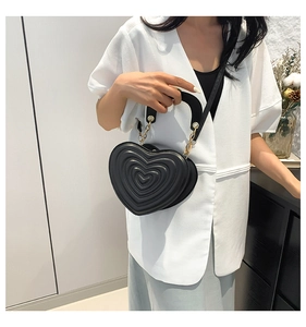 Detailansicht der schwarzen Herz-Handtasche mit Steppnaht und goldener Kette