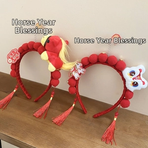 Close-up of festive red headbands with dancing lion and horse dolls with red tassels