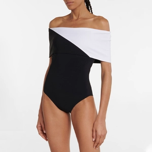 Detail of elegant black and white patchwork one-piece swimsuit with off-shoulder V-neckline