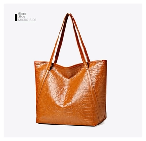 Close-up of the vintage brown crocodile texture and double strap design on this tote bag