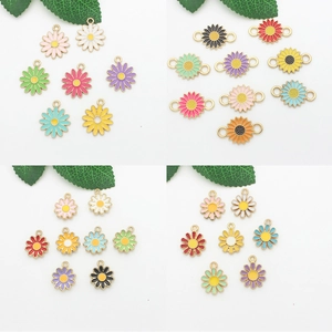 Macro detail of colorful enamel daisy charms with gold metal edges for DIY jewelry making