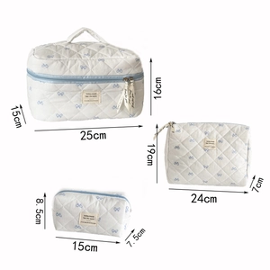 Detailed size view of three blue bow quilted makeup bags showing precise dimensions