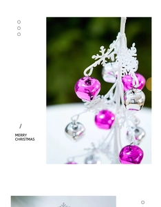 Detail eines weißen Zweigständers mit glänzenden rosa und silbernen Glocken für Weihnachten