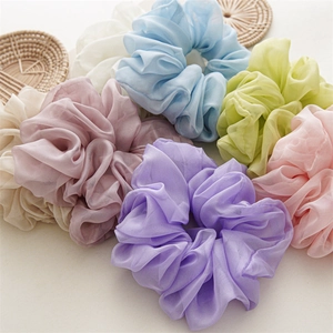 Set of 7 large solid color chiffon scrunchies in pastel tones on a neutral background