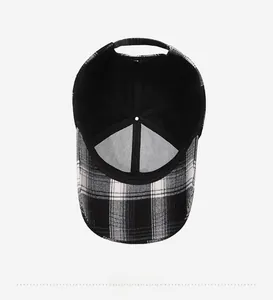 Detail view of the black and white plaid baseball cap showing inner lining and strap