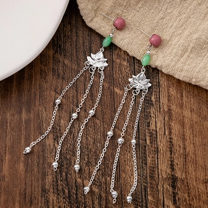 Detail of beaded tassel earrings with silver lotus flower and green emerald beads