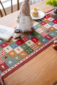 Close-up of woven jacquard Christmas table runner with festive patchwork snowman patterns