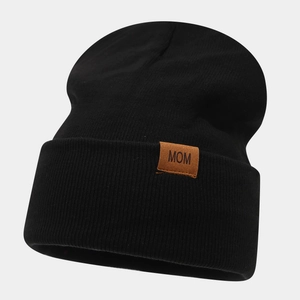 Close-up of black ribbed knit beanie featuring a brown leather patch with MOM lettering