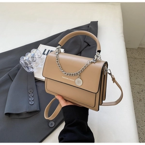 Detail of khaki PU leather bag featuring elegant metal chain and fashion lettering