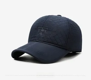 Detail view of navy blue quilted winter cap with ear flaps and embroidery