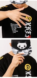 Gros plan de bagues en acier brossé avec un t-shirt streetwear et une casquette panda