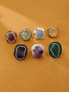 Detail of seven Bohemian irregular raw stone rings with crystal pave on gold metal bands